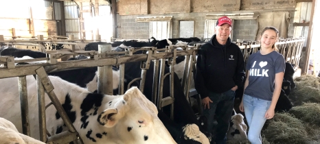 farmers pose next to cattle grazing