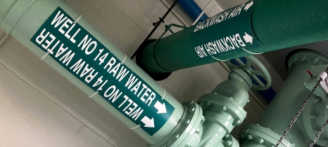 large pipes painted green and labeled Well No. 14 Raw Water